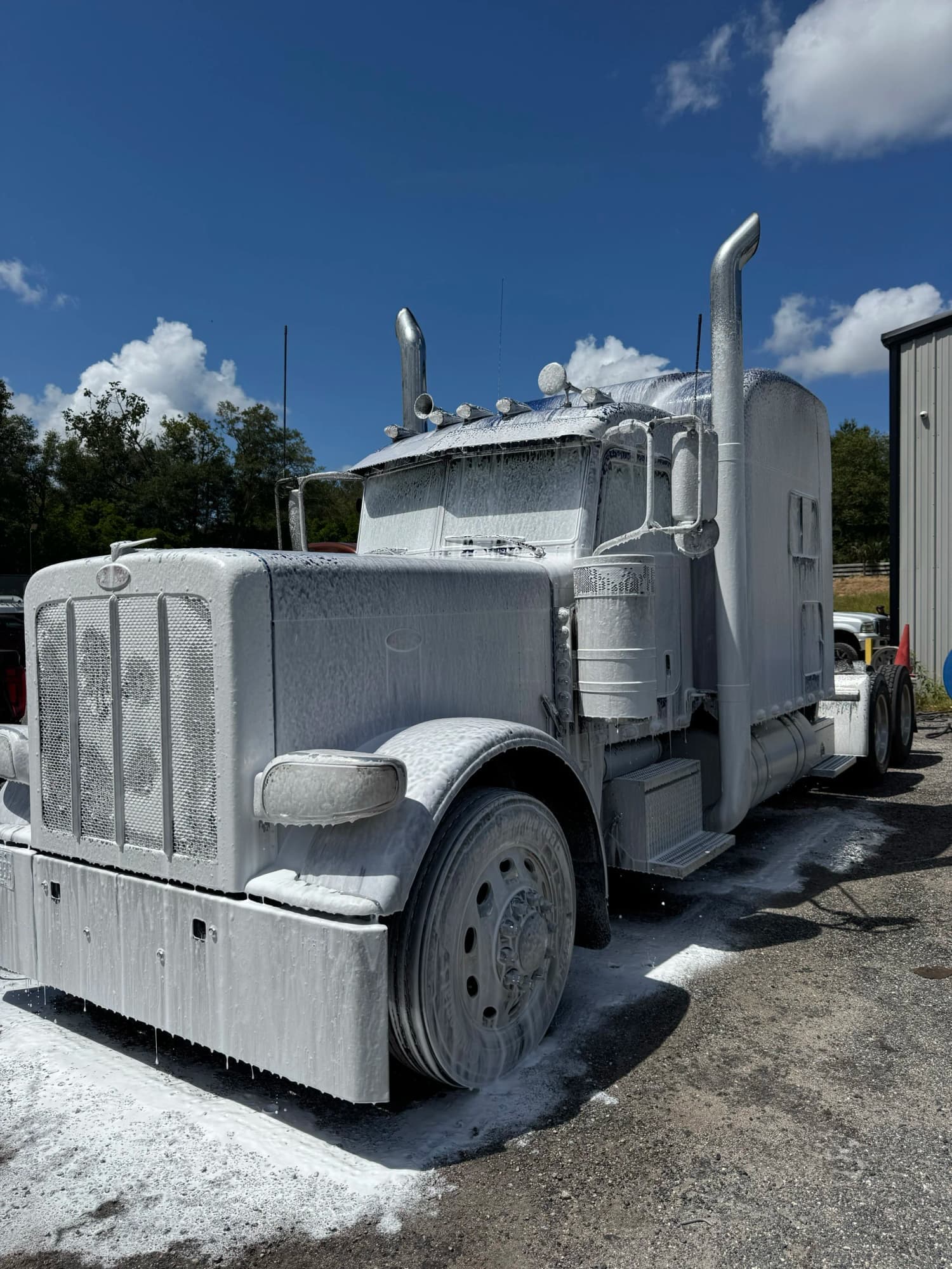 Semi truck fully covered in cleaning foam during a TM fleet wash